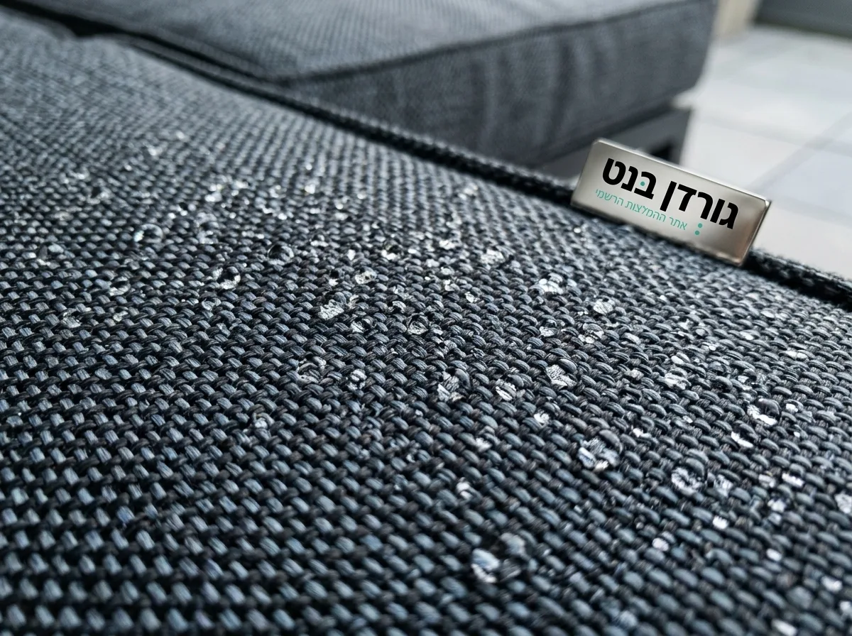 צילום תקריב איכותי של בד ריפוד עבה לריהוט חוץ, מים עומדים עליו בטיפות מושלמות מבלי להיספג, מדגים דחיית מים טכנולוגית